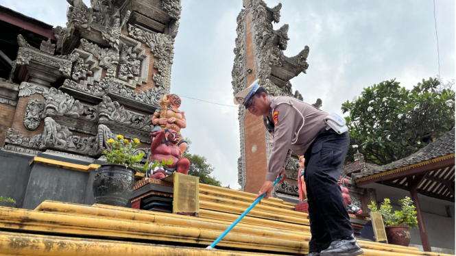 Polisi lalu lintas sedang menyapu di Pura