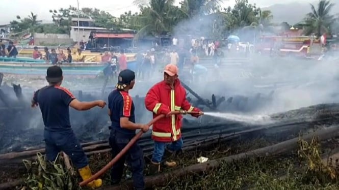 Petugas memadamkan kobaran api Eks Kapal Motor Siwa Jaya.