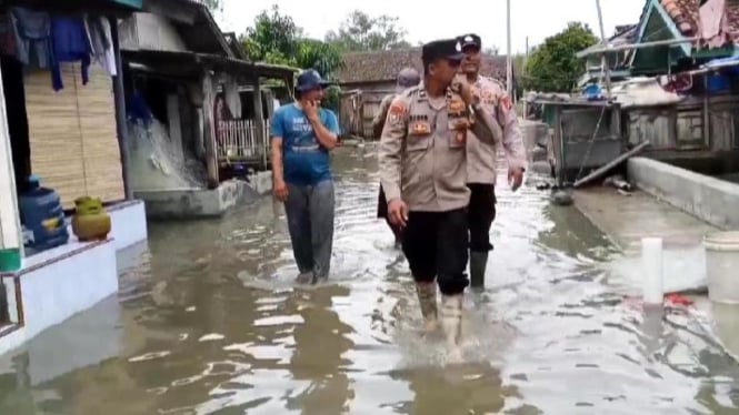 Polisi melakukan patroli ke rumah warga yang terendam banjir rob.