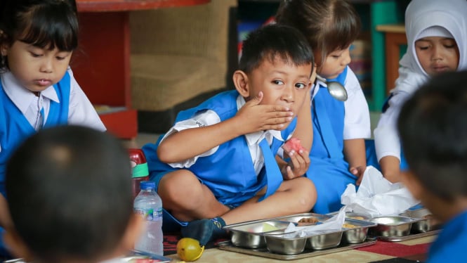 Siswa sekolah sedang menyantap Makanan Bergizi Gratis