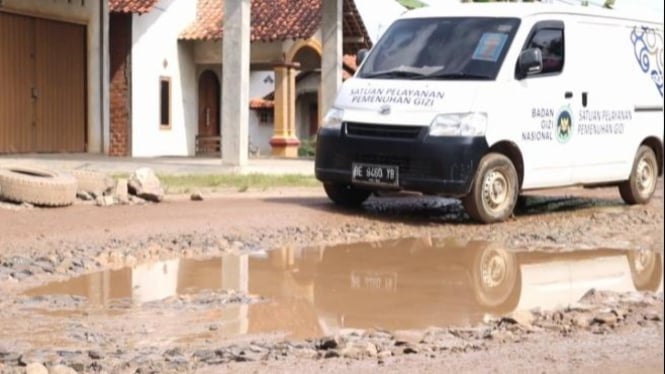 Mobil membawa makanan bergizi gratis lalui jalan rusak di Lampung.