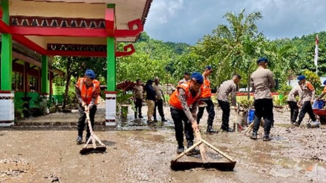 brimob polda lampung membersihkan sisa banjir di Bandar Lampung.