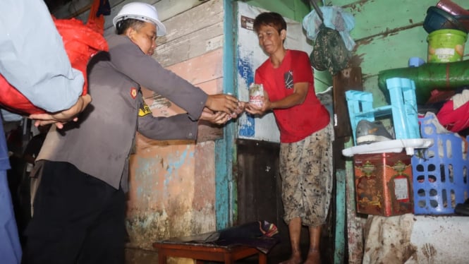 Polisi membagikan nasi bungkus ke warga terdampak banjir.