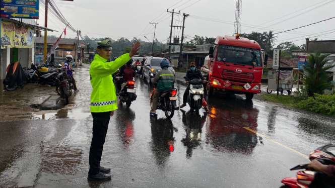 Satlantas Polres Pesawaran atur arus lalulintas saat hujan turun.