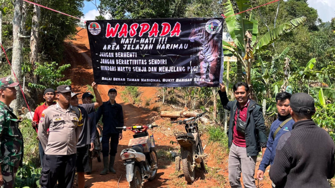 Pemasangan banner berisi himbauan bahaya Harimau.