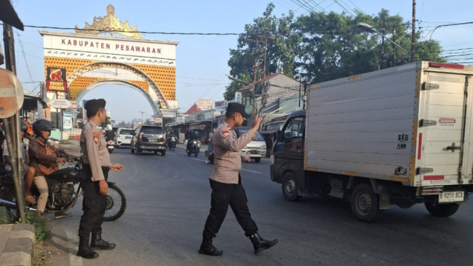 Polsek Gedong Tataan mengatur arus lalulintas kendaraan.