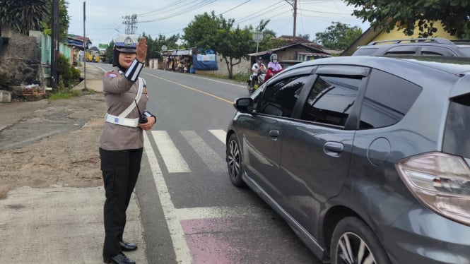 Polwan Satlantas Polres Pesawaran mengatur arus lalulintas.