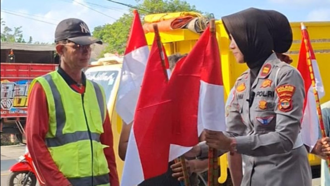 Satlantas Polres Pesawaran bagikan bendera merah putih.