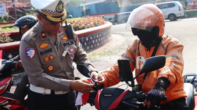 Kasatlantas saat memasangkan bendera