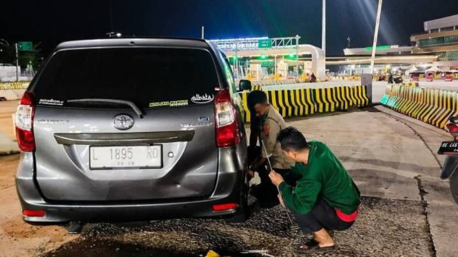 Aipda Sigit bantu ganti ban mobil Pemudik di Tolgate Bakauheni.