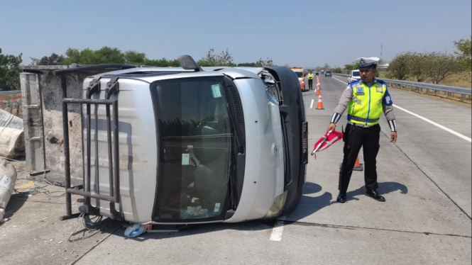 Kendaraan yang terguling akibat pecah ban.