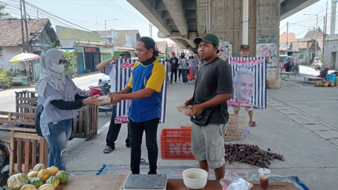 Relawan Ganjar bagikan nasi kotak pada pedagang dan tukang becak.