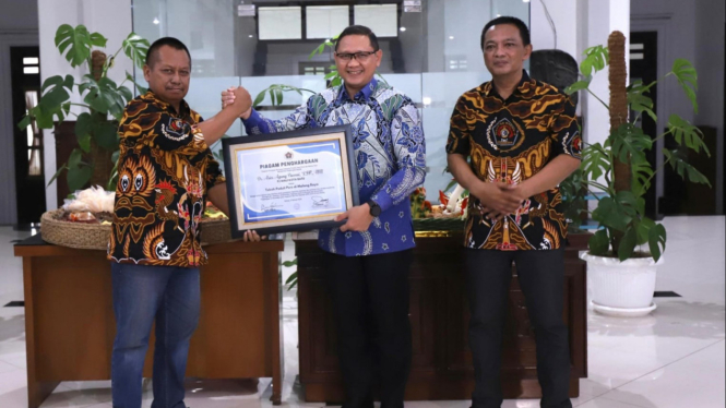 Pj Wali Kota Batu, saat menerima penghargaan dari PWI Malang Raya.