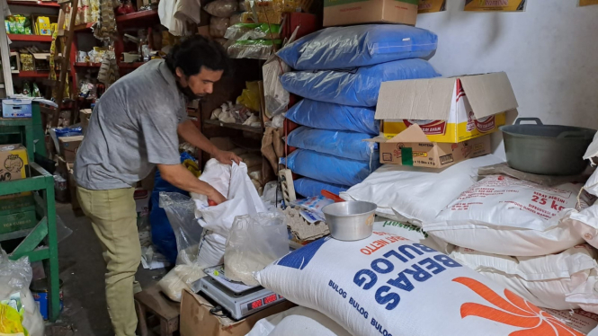 Pedagang di Pasar Blimbing menimbang beras bulog kemasan 50 kilogram.