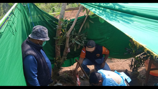 Petugas saat membongkar makam diduga janin bayi