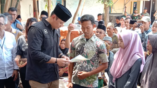 Menteri AHY menyerahkan langsung sertifikat tanah kepada warga.