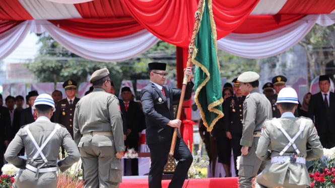 Pj Wali Kota Batu Aries Agung Paewai menyerahkan pataka.