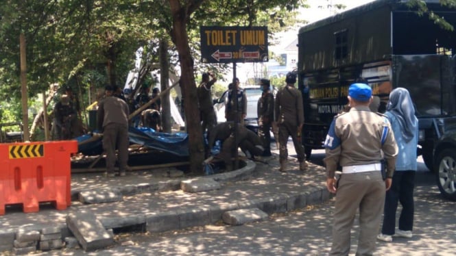 Satpol PP Kota Batu saat membersihkan sisa bangunan.