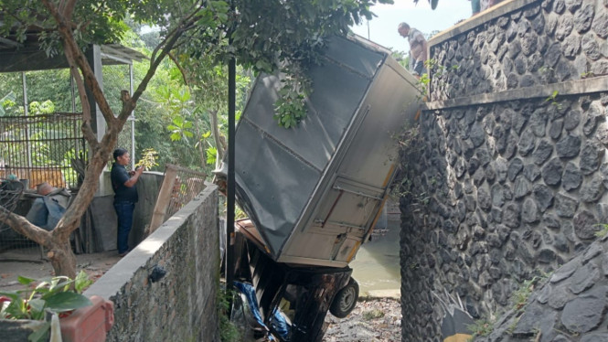 Kendaraan mobil box yang masuk ke dalam sungai.
