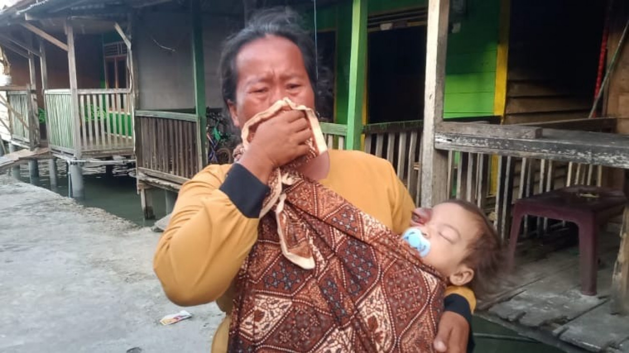 Titi Suwarni mengendong anaknya yang tidak bisa melihat.
