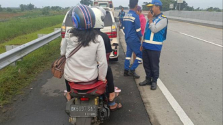 Petugas menghentikan pesepeda motor yang menerobos masuk tol. Petugas menghentikan pesepeda motor yang menerobos masuk tol.