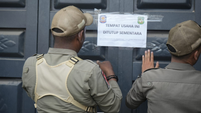 Petugas Satpol PP menyegel panti pijat yang buka saat Ramadan.