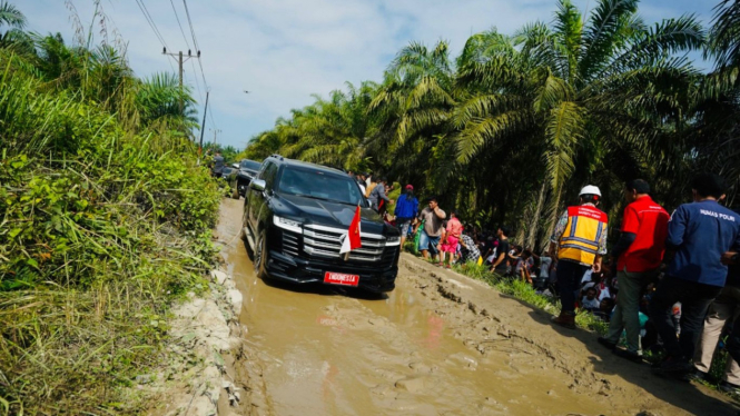 Mobil yang ditumpangi Presiden RI Joko Widodo melintasi jalan rusak di Labura, Sumut.