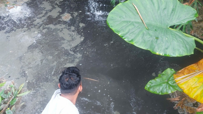 Warga menunjukkan saluran drainase yang berbuih dan berbau yang diduga akibat pencemaran pabrik sabun di Patumbak, Deliserdang.