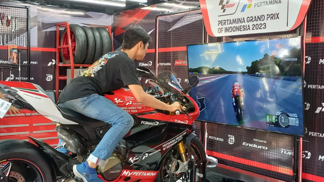 Aksi pengunjung merasakan sensasi simulator  Pertamax Turbo The Ultimate Box MotoGP.