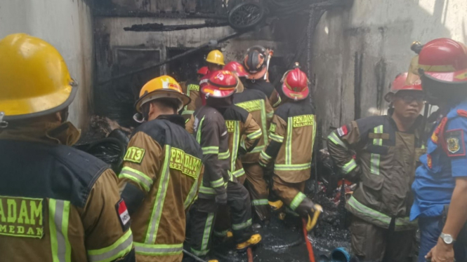 Petugas pemadam padamkan api yang membakar rumah di Medan.