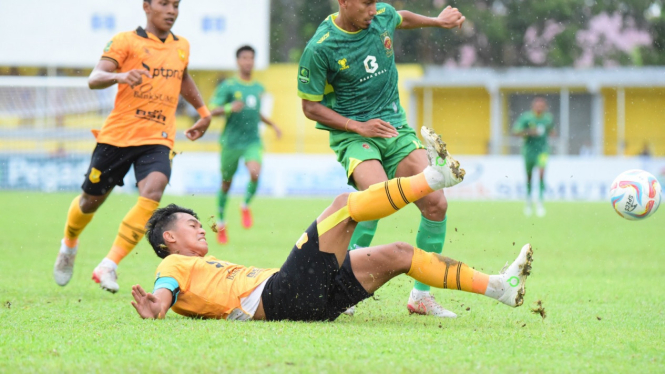 Pemain PSDS, Ilham Wibowo Yusuf (kuning) menahan serangan pemain Sriwijaya FC.