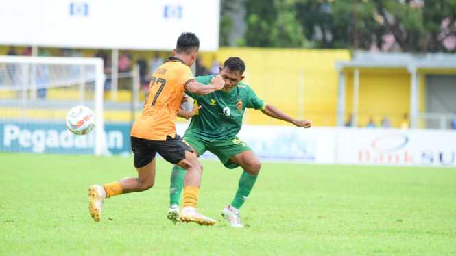 Pemain PSDS (kuning) menahan serangan pemain Sriwijaya FC.