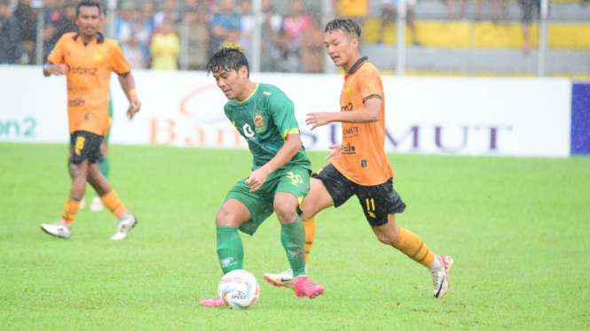 Pemain PSDS Deli Serdang (kuning) menghalau serangan pemain Sriwijaya FC.