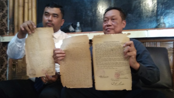 Kuasa hukum Edy Suhairi dan Farid Faturrahman menunjukkan dokumen kepemilikan tanah kliennya.