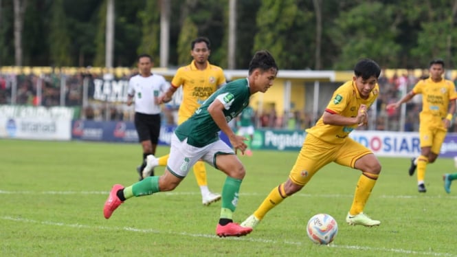 Pemain Semen Padang (kuning) berusaha merebut bola dari pemain PSMS.