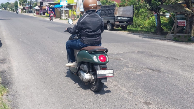 Pengendara sepeda motor melintas di jalan perbatasan Binjai - Langkat yang kembali rusak.