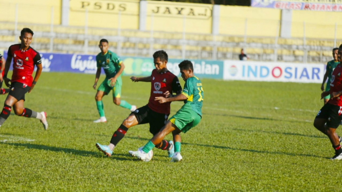 Pemain Sada Sumut FC (merah) berebut bola dengan pemain Sriwijaya.