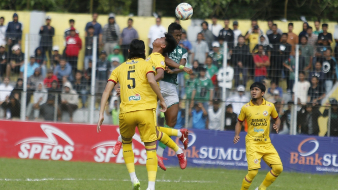 Pemain PSMS, Joko Susilo berebut bola dengan pemain Semen Padang.