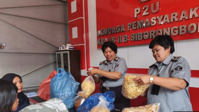 Petugas Lapas Siborongborong memeriksa barang bawaan pengunjung warga binaan.