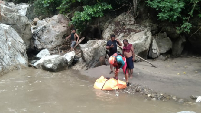 Petugas Basarnas mengevakuasi korban Firman Ginting yang tewas terseret arus sungai.