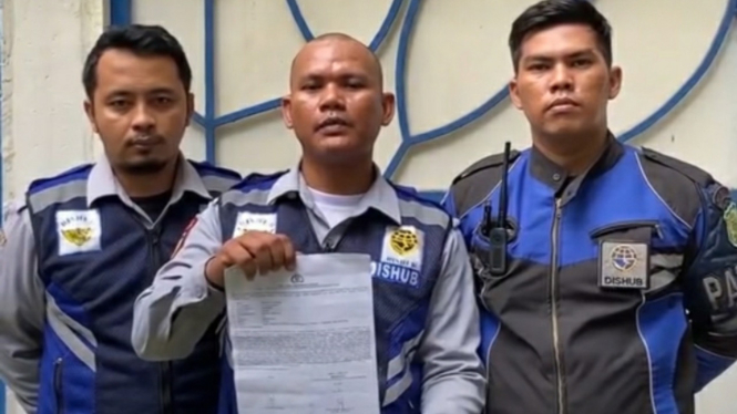 Petugas Dishub Medan menunjukkan surat laporan pedagang martabak ke polisi.