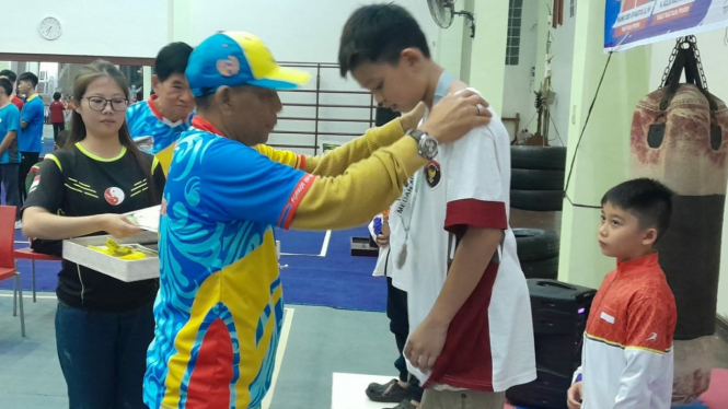 Ketua KONI Medan, Eddy H Sibarani  menyematkan medali kepada juara Wushu Porkot Medan 2024.