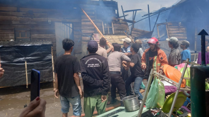 Warga bersama petugas memadamkan api yang membakar puluhan rumah di Desa Dokan Kecamatan Merek, Kabupaten Karo.