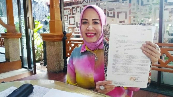 Henny Harahap menunjukkan surat keterangan laporan ke Polda Sumut.