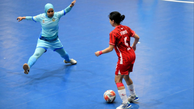 Pemain futsal putri Sumut (merah) dikawal pemain DKI Jakarta pada pertandingan babak penyisihan grup PON 2024.