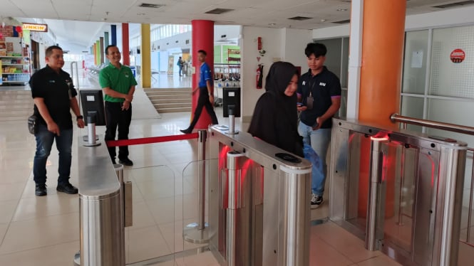 Penumpang kereta api melintasi Face Recognition Boarding Gate di Stasiun Medan.