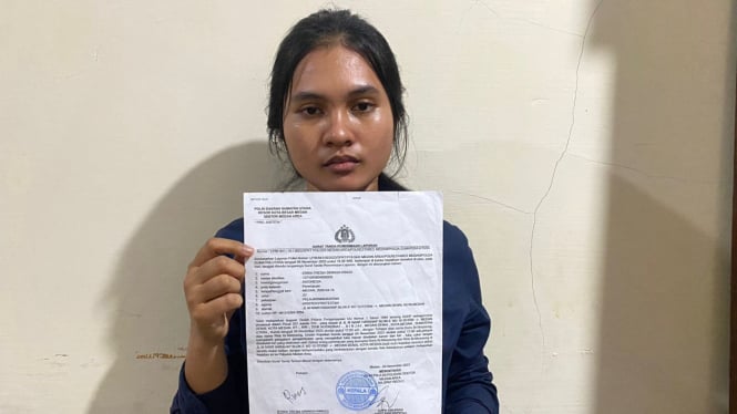 Korban penganiayaan kakak beradik, Erika Tresia Siringoringo menunjukkan surat laporan.