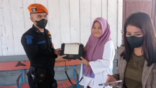 Petugas keamanan stasiun kereta api, saat mengembalikan barang penumpang yang ketinggalan.