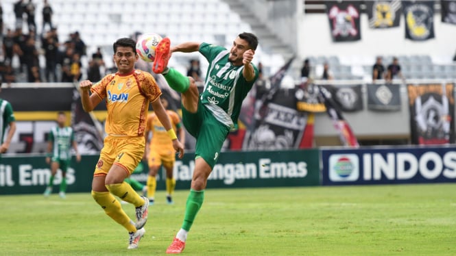 Pemain PSMS Medan, Juninho Cabral dikawal pemain Sriwijaya FC.