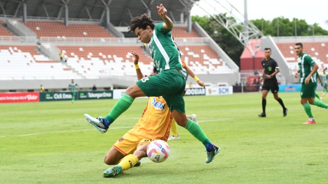 Pemain PSMS Medan dikawal pemain Sriwijaya FC.